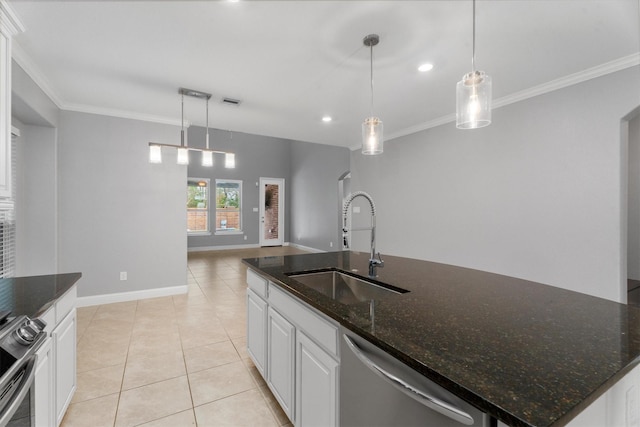 kitchen featuring pendant lighting, stainless steel appliances, dark stone countertops, and an island with sink