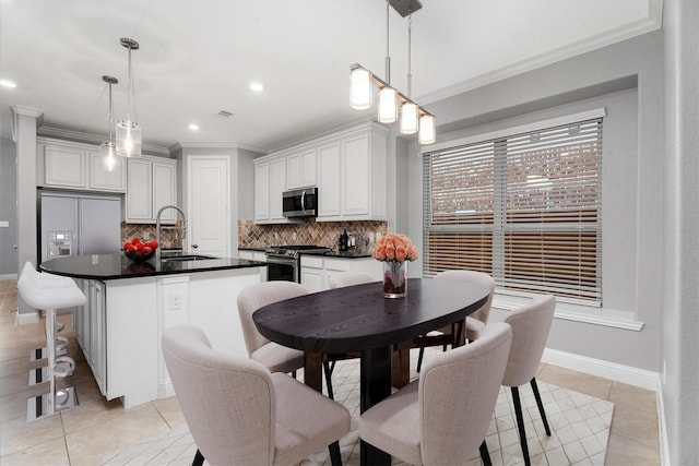 dining area with light tile patterned flooring, ornamental molding, and sink