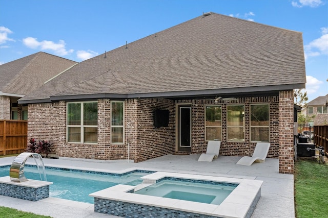 rear view of house with pool water feature and a pool with hot tub