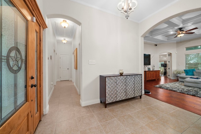 hallway with coffered ceiling, beamed ceiling, a chandelier, light hardwood / wood-style floors, and ornamental molding