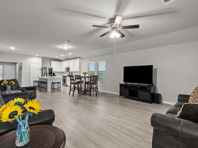 living room with ceiling fan and light hardwood / wood-style flooring