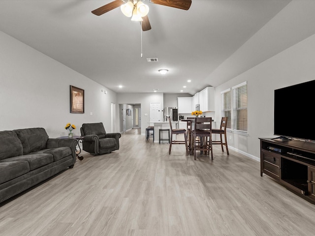 living room featuring ceiling fan and light hardwood / wood-style flooring