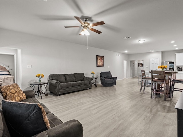 living room featuring light hardwood / wood-style floors and ceiling fan