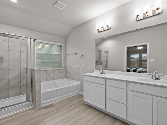 bathroom featuring hardwood / wood-style floors, vanity, a healthy amount of sunlight, and lofted ceiling