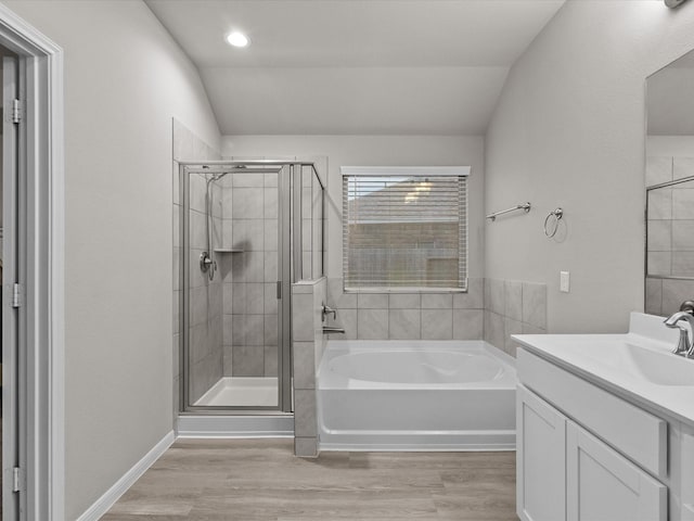 bathroom with vanity, wood-type flooring, lofted ceiling, and independent shower and bath