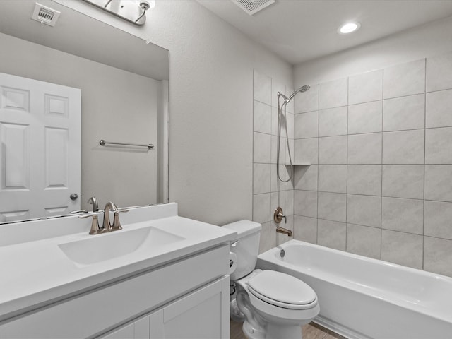 full bathroom with tiled shower / bath combo, toilet, and vanity