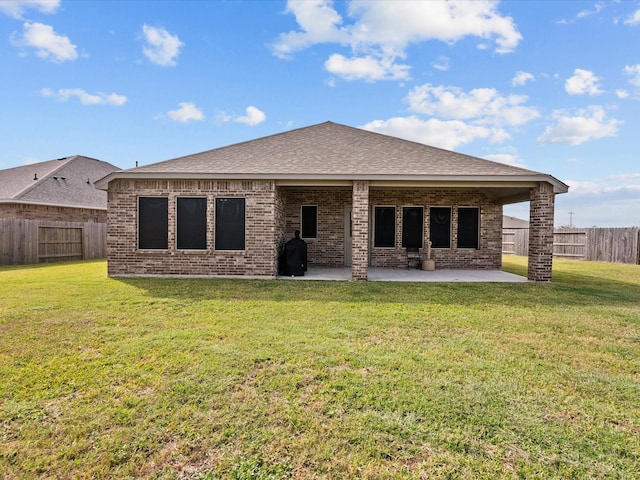 rear view of house featuring a patio and a lawn