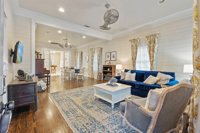 living room with dark hardwood / wood-style floors, ceiling fan, crown molding, and wood walls