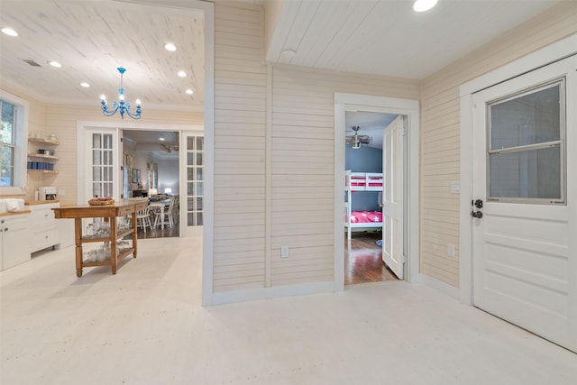 hallway with concrete flooring, french doors, an inviting chandelier, and wood ceiling