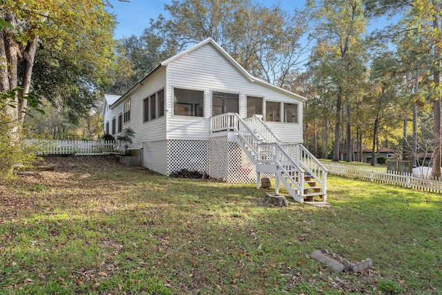 view of front of house with a front yard and a sunroom