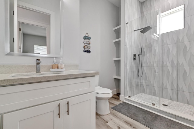 bathroom featuring vanity, a healthy amount of sunlight, toilet, and wood-type flooring