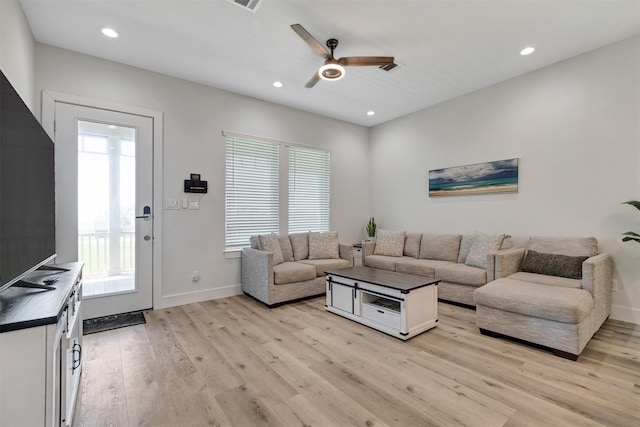 living room featuring a wealth of natural light, light hardwood / wood-style flooring, and ceiling fan