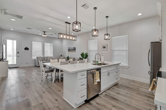 kitchen featuring sink, hanging light fixtures, light hardwood / wood-style flooring, white cabinetry, and stainless steel appliances