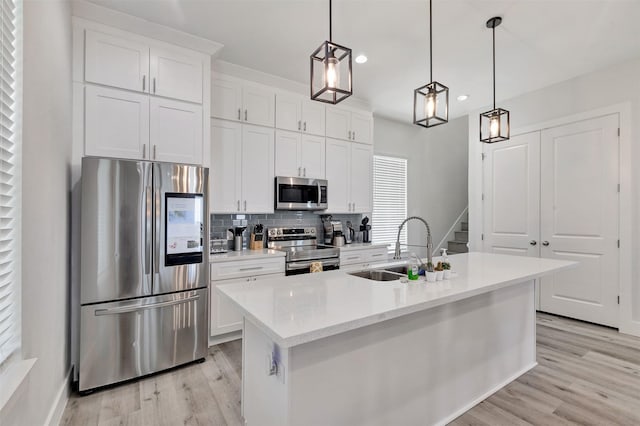 kitchen with white cabinetry, sink, an island with sink, and stainless steel appliances