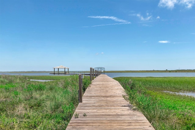 view of dock with a gazebo and a water view