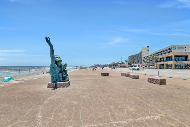 view of property's community with a water view and a view of the beach