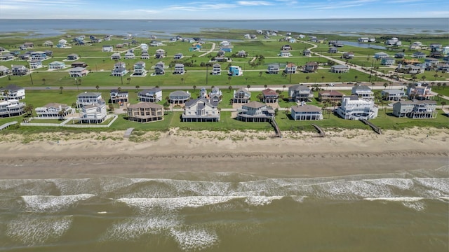 bird's eye view with a water view and a beach view