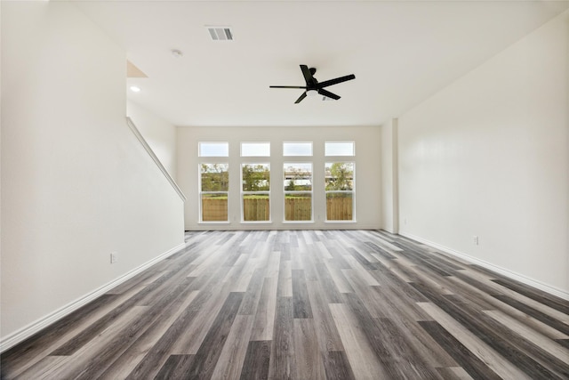 unfurnished living room with ceiling fan and dark wood-type flooring