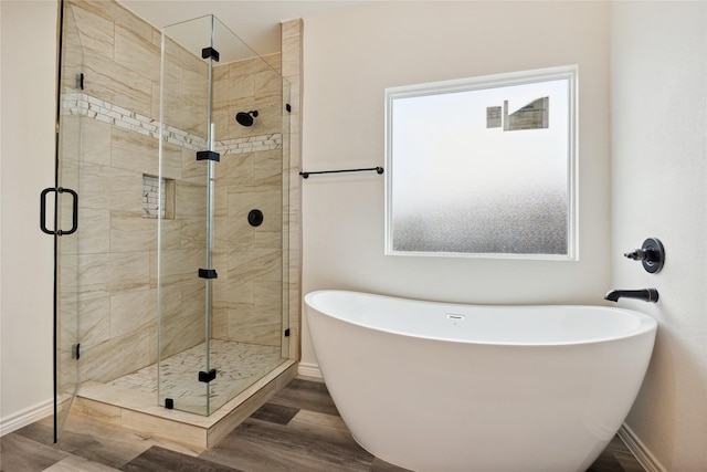 bathroom with hardwood / wood-style floors and independent shower and bath