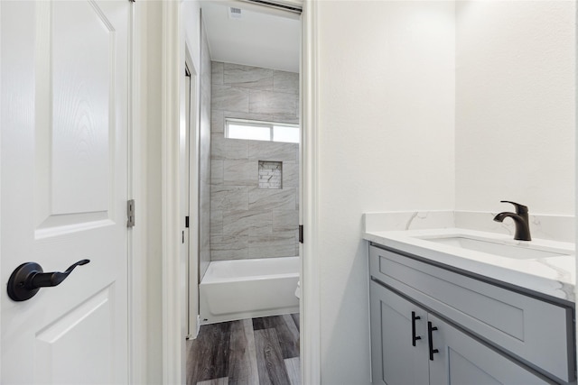 bathroom featuring vanity, wood-type flooring, and tiled shower / bath