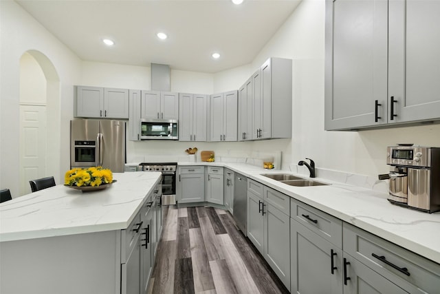 kitchen featuring gray cabinetry, sink, light stone countertops, appliances with stainless steel finishes, and dark hardwood / wood-style flooring