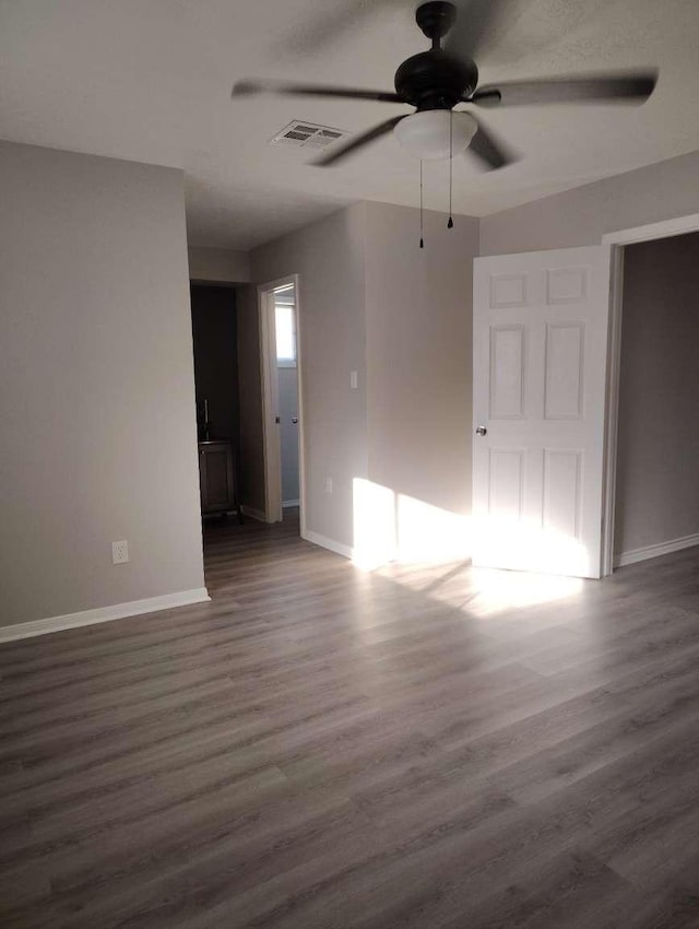 empty room featuring dark hardwood / wood-style flooring and ceiling fan