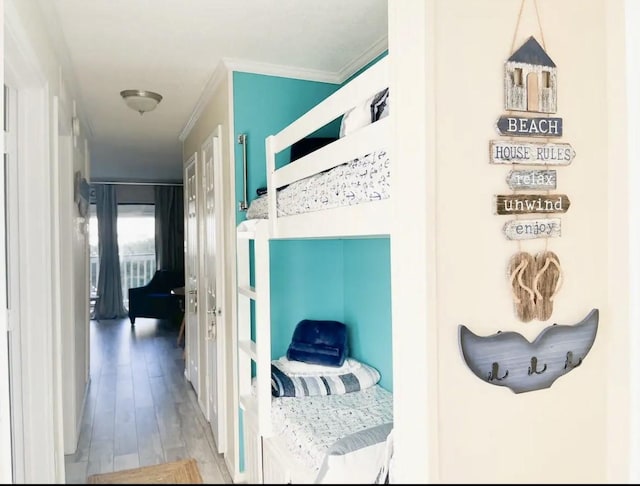 bedroom with wood-type flooring and ornamental molding