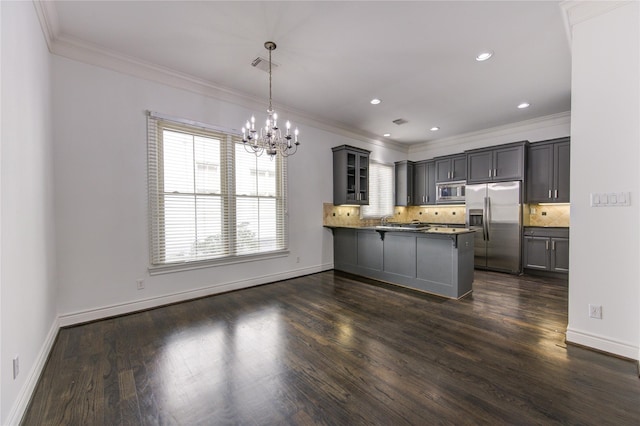 kitchen featuring kitchen peninsula, appliances with stainless steel finishes, tasteful backsplash, crown molding, and hanging light fixtures