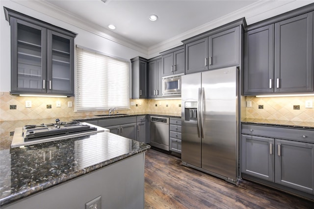 kitchen with dark wood-type flooring, sink, decorative backsplash, dark stone countertops, and stainless steel appliances