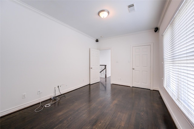 empty room with dark hardwood / wood-style floors and ornamental molding