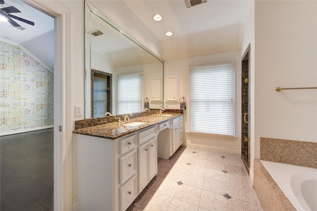 bathroom with ceiling fan, tiled bath, vanity, and vaulted ceiling