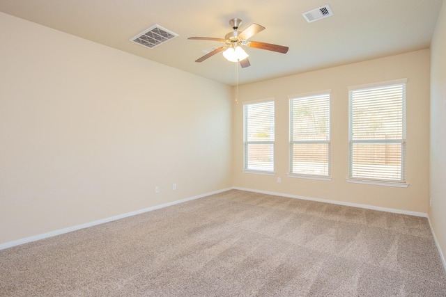 carpeted spare room featuring ceiling fan and a healthy amount of sunlight