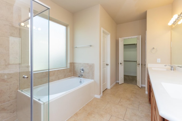 bathroom featuring tile patterned flooring, vanity, and separate shower and tub