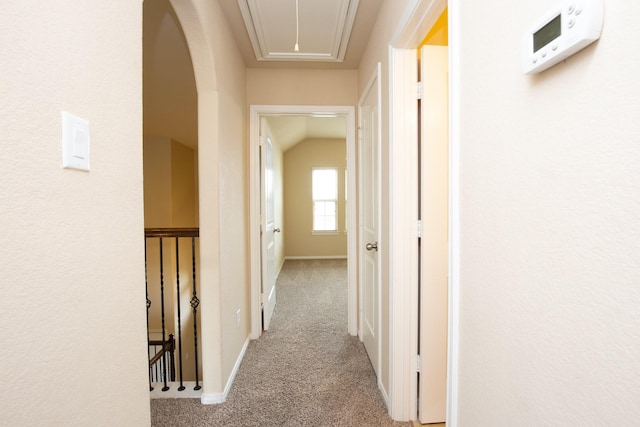 corridor with light colored carpet and lofted ceiling