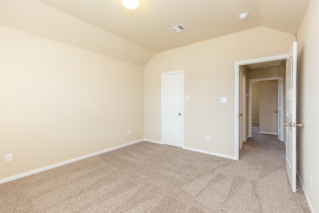 unfurnished bedroom featuring light colored carpet and vaulted ceiling