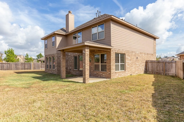 back of property featuring a lawn and a patio