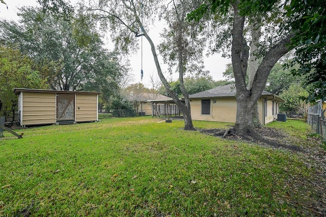 view of yard featuring a storage unit and central air condition unit