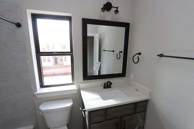 bathroom featuring a wealth of natural light, vanity, and toilet