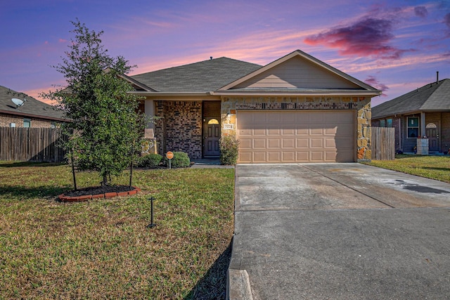 ranch-style home featuring a lawn and a garage