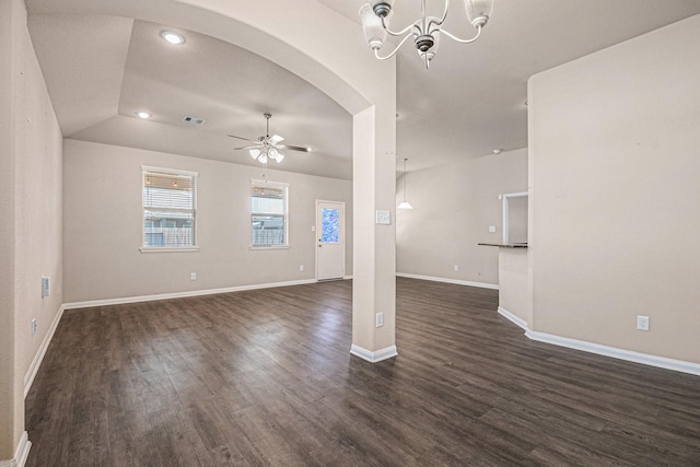 unfurnished living room featuring vaulted ceiling, ceiling fan with notable chandelier, and dark hardwood / wood-style floors