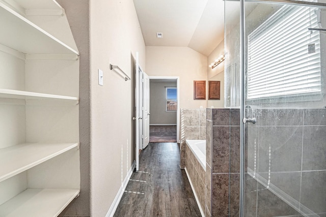 corridor with a healthy amount of sunlight, dark hardwood / wood-style flooring, and lofted ceiling