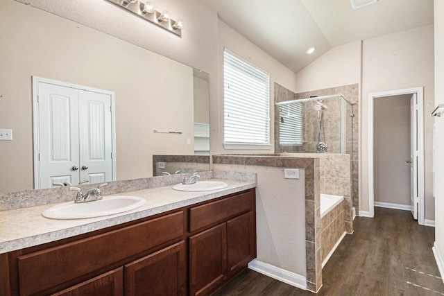 bathroom with plus walk in shower, vanity, lofted ceiling, and hardwood / wood-style flooring