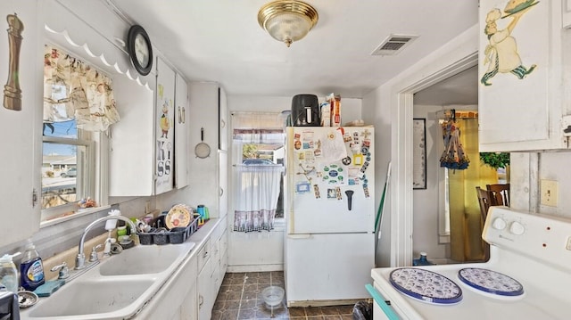 kitchen with sink, white cabinets, and white appliances