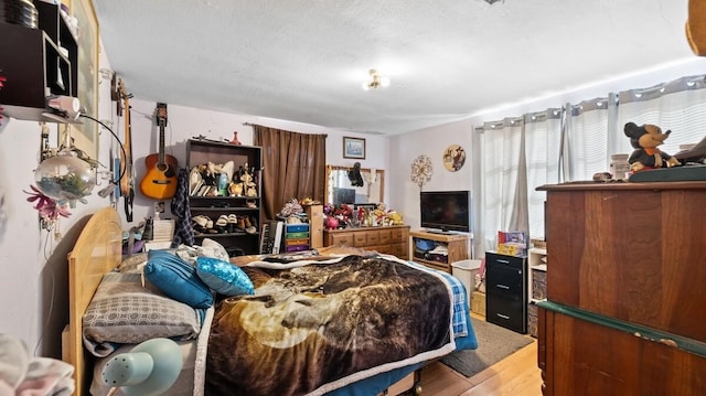 bedroom with wood-type flooring and a textured ceiling