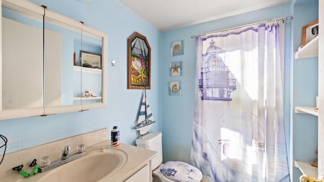 bathroom featuring walk in shower, vanity, and toilet