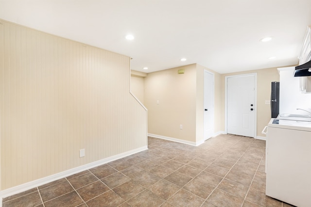 clothes washing area featuring tile patterned floors, washer / dryer, and wooden walls