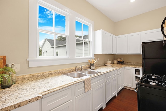 kitchen featuring sink, dark hardwood / wood-style floors, white cabinetry, and black appliances