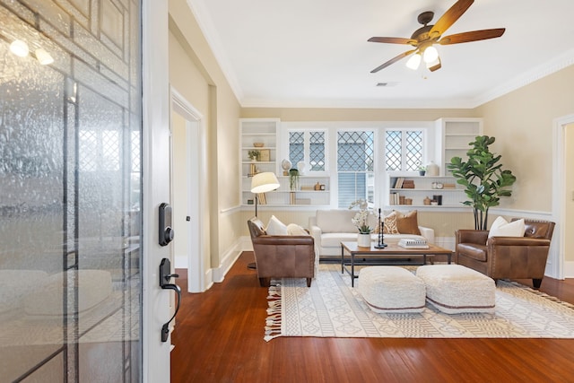 living room with hardwood / wood-style flooring, ceiling fan, and crown molding