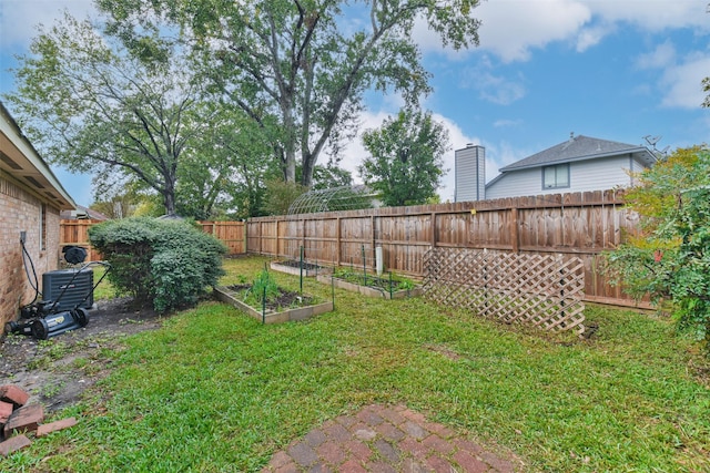 10306 Wayward Wind Ln, Houston, TX 77064 - view of yard with a fenced backyard, a vegetable garden, and central AC