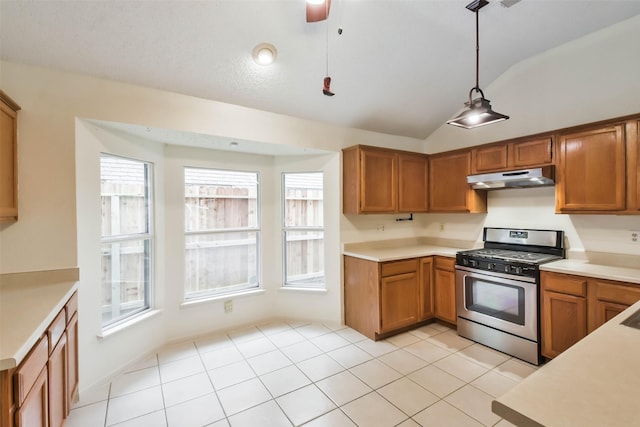 kitchen with ceiling fan, stainless steel range with gas cooktop, pendant lighting, vaulted ceiling, and light tile patterned flooring